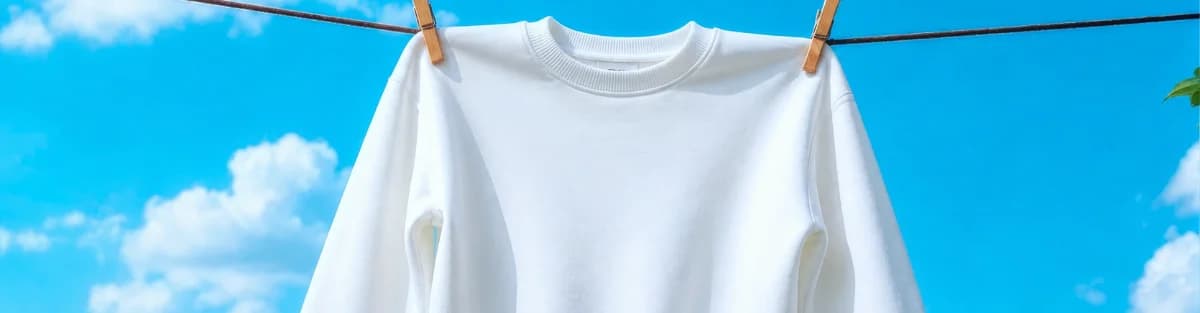 A freshly laundered white shirt hanging on a clothesline against a blue sky